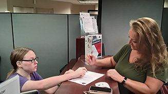 ATC Staff helps student with paper work.  